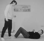 A person standing over a person lying on the ground

Description automatically generated with low confidence